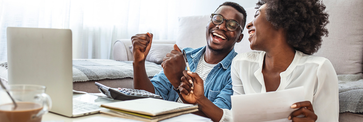 Happy couple at computer in their living room